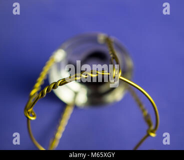 Muselet aus der Flasche Champagner. Auf blauem Hintergrund isoliert. Selektiver Fokus Stockfoto