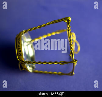 Muselet aus der Flasche Champagner. Auf blauem Hintergrund isoliert. Selektiver Fokus Stockfoto