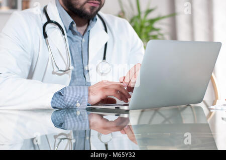 Arzt Arbeiten am Schreibtisch mit Laptop in der Arztpraxis. Medizin, Arzt Konzept Stockfoto