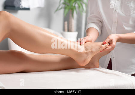 Beauty Behandlung Konzept. Schöne Frau in Fuß Massage im Spa Salon Stockfoto