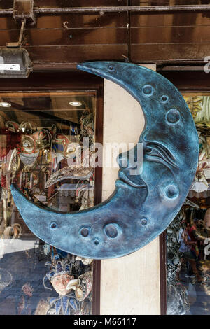 Große Halbmondskulptur, als Schild, außerhalb eines typischen venezianischen Karnevalsmasken-Shops. Magisches Venedig, Italien, Europa, Europäische Union, EU. Stockfoto