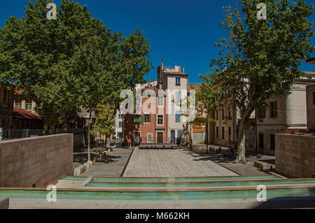 Ruhigen Platz mit Teich, Bäume, Gebäude und blauer Himmel im Zentrum der Stadt von Nimes. In der Occitanie Region im Süden Frankreichs. Stockfoto