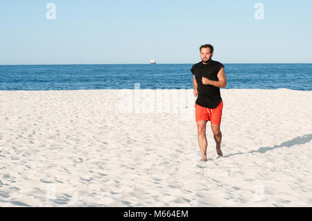 Man läuft am Strand. Mann, Athlet, laufende Übung am Meeresufer. Stockfoto