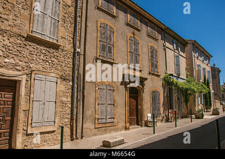 Blick auf typische Häuser aus Stein und Geschäfte auf einer Straße des historischen Dorf Lourmarin. In der Region Provence, Südfrankreich. Stockfoto
