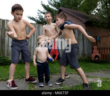 Vier kaukasischen Jungen spielen Mit sprizen Gewehren und Einander bei einem warmen Sommertag Stockfoto