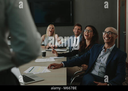 Happy Geschäftsleute hören auf Ihre Kollegen während einer Besprechung und Lachen. Business Männer und Frauen lachen während einer Konferenz in Stockfoto