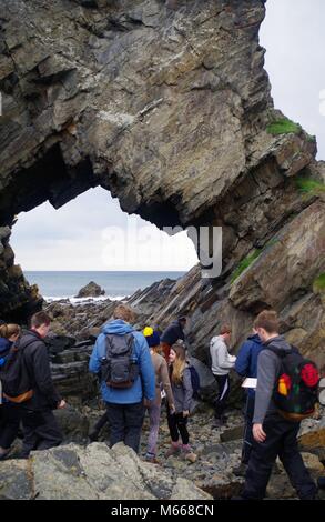 Das Nadelöhr, natürlichen Felsbogen Loch Bildung. Macduff, Aberdeenshire, Schottland, Großbritannien. Auf einer Universität Geologie Exkursion. Stockfoto