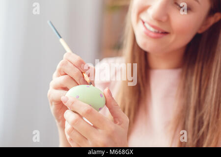 Junge Frau zu Hause Ostern celbration Konzept sitzen färben Eier machen Punkte close-up Stockfoto