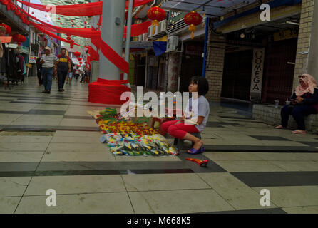 Junge Kind durch den Verkauf von Waren aus einem Vertrag, India Street, Kuching, Sarawak, Malaysia Stockfoto