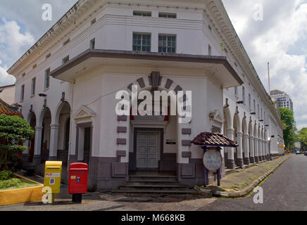 Rote und gelbe Post Briefkästen außerhalb der Alten Post in Kuching, Malaysia, eine gut gepflegte Beispiel der britischen kolonialen Architektur Stockfoto