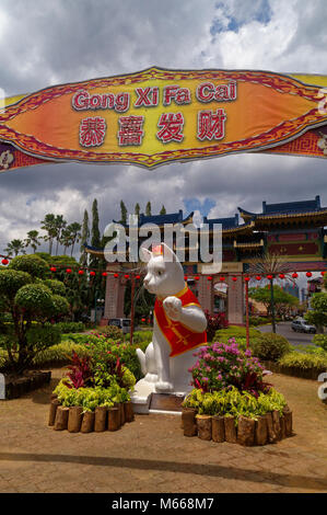 Das Wahrzeichen white cat Statue auf Jalan Pdungan, Kuching, Sarawak, Malaysia, in Rot für das chinesische Neujahr gekleidet Stockfoto