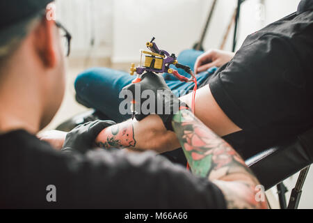 Tattoo Maschine Zeichnung auf die männliche Hand. Stockfoto