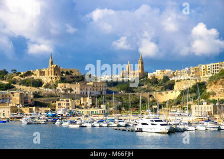 Gozo, Malta. Die zweite Insel in der Größe in Malta. Blick auf den Hafen mit den alten Cit und Kathedrale in den Rücken. Sonnenuntergang. Stockfoto