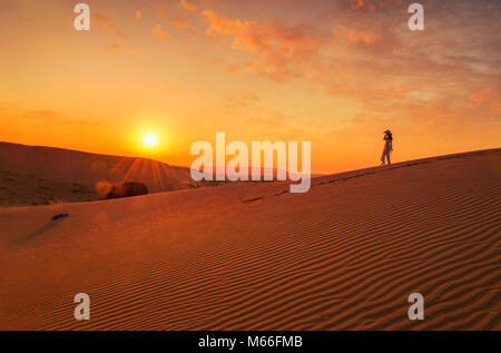 Frau, die auf einem Grat einer Sanddüne entlang geht, Mui Ne, Phan Thiet, Vietnam Stockfoto
