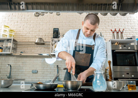 Im Mittelpunkt chef Vorbereiten einer Polenta im Restaurant Küche kochen. Stockfoto