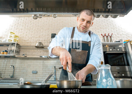 Im Mittelpunkt chef Vorbereiten einer Polenta im Restaurant Küche kochen. Stockfoto