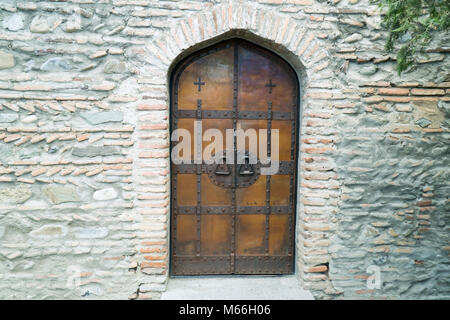 Alte Holz gerahmt Metall Tür in einer Wand Stockfoto