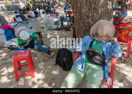 Bali, Indonesien - 24. August 2016: Unbekannter balinesischen sarong Anbieter Rest in im Schatten am Strand. Stockfoto