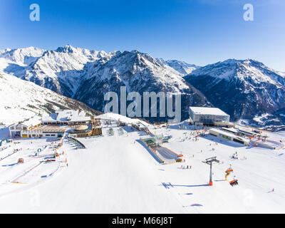 Skigebiet in den Alpen mit Skilift und Menschen Skifahren auf der Piste Stockfoto
