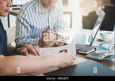 Junge Hipster Arbeitskraft auf kleinen Notebook beim Treffen mit Kollegen im coworking Space schreiben. Freelancer-Teamwork und Brainstorming-Konzept Stockfoto