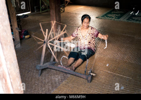 Eine ethnische ältere Frau Spinnen Garne in einem kleinen Tribal Dorf direkt an der Nam Ou Fluss in Laos. Stockfoto