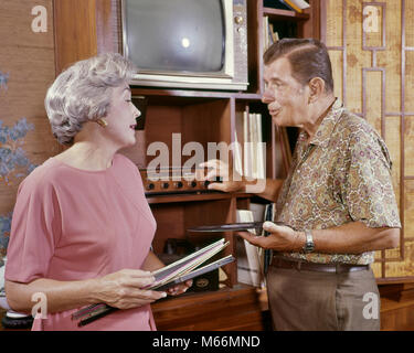 1960 älteres Paar HÖREN VON MUSIK MANN DREHEN STEREO PLATTENSPIELER WÄHLEN WOMAN HOLDING LP SCHALLPLATTE ABDECKUNGEN - km 1748 HAR 001 HARS LIFESTYLE SOUND ÄLTERE FRAUEN EHEMÄNNER GROWNUP HOME LEBEN KOMMUNIKATION KOPIEREN RAUM FREUNDSCHAFT halber Länge Damen erwachsene Paare im Innenbereich Unterhaltung älterer Mann älterer Erwachsener NOSTALGIE PLATTENSPIELER ZWEISAMKEIT STEREO SENIOR FRAU 55-60 Jahre 60-65 JAHRE WÄHLEN FRAUEN GLÜCK OLDSTERS ALTEM FREIZEITAKTIVITÄTEN PLATTENSPIELER TUNING ÄLTESTEN VERBINDUNG ZUSAMMENARBEIT KOMMUNIZIEREN DECKT HIFI LPS MÄNNER ALBEN KAUKASISCHEN ETHNIE ENTERTAINMENT CENTER LANGE SPIELEN ALTMODISCH Stockfoto