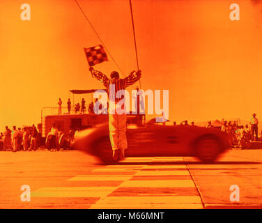 1970 s Mann winkte karierten Flagge an der Ziellinie ENDE DES SPORTS CAR RACE ORANGE FILTER - km 3108 HAR 001 HARS AUTOMOBIL UNTERHALTUNG TRANSPORT NOSTALGIE ZIELE ERFOLG ABENTEUER SIEG KRAFTFAHRZEUG AUFREGUNG FÜHRUNG FREIZEIT RICHTUNG FAHRENDE BEWEGUNGSUNSCHÄRFE MOBILITÄT SYMBOLISCHE KARIERTEN MÄNNER SPORTWAGEN ZIELLINIE ZIELLINIE BERUFE ALTMODISCHE PERSONEN Stockfoto