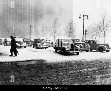 1940 anonyme SILHOUETTED FUSSGÄNGERÜBERWEG ORT STRASSE IM WINTER mit Schnee auf der Straße und der AUTOVERKEHR NYC NEW YORK USA-t 762 HAR 001 HARS 30-35 Jahre 35-40 Jahre 40-45 Jahre WINTERSAISON FUSSGÄNGERZONE STÄDTISCHE ZENTRUM SILHOUETTED AUTOS GOTHAM NYC SLUSH NEW YORK JAHRESZEIT AUTOMOBILE STÄDTE MOBILITÄT FAHRZEUGE WALKER NEW YORK CITY Anonyme Mitte - Mitte - ERWACHSENE MAN B&W SCHWARZ UND WEISS ALTMODISCHE PERSONEN Stockfoto