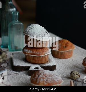 Hausgemachte Muffins mit Zucker Pulver Sahnehäubchen auf alten hölzernen Board Stockfoto