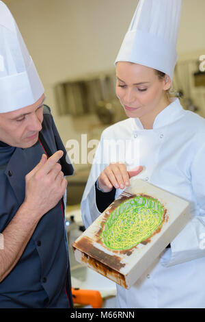 Konditoren schmückt einen Kuchen in einem Candy Store Stockfoto