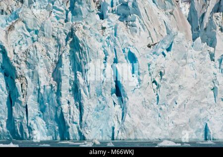 Blick auf einem Gletscher in Alaska Fjorde mit treibenden Eisblöcke im Wasser. Eis Wand Hintergrund mit blauen Tönen. Globale Erwärmung Stockfoto