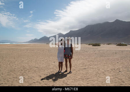 Glücklich, das junge Paar portrait am Strand. Full Shot, mit malerischem Hintergrund. Fuerteventura, Kanarische Inseln, Spanien. Stockfoto