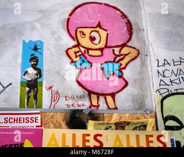 Altersschwaches Wand eines Berliner Gebäude. Alte El Bocho "Little Lucy" Artwork disapperaing unter Poster und Graffiti Stockfoto