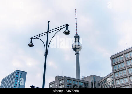 Berlin, Mitte, Alexanderplatz. Fernsehturm Television Tower, alte Lampe Post und die aufgeführten Peter Behrens Bauhaus Gebäude. Die liste Stockfoto