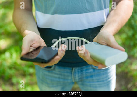 Bild von Mann mit Telefon und Power Bank Stockfoto