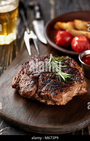 Saftige Steak medium Rindfleisch mit Gewürzen auf Holzbrett auf Tisch Stockfoto