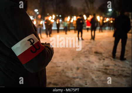 Krakau, Polen. 28 Feb, 2018. Ein Mitglied der polnischen Konservativen rechten Flügel der Bewegung mit seiner politischen Partei logo Armband gesehen, wie er einen schweigemarsch Für die nationalen Gedenktag der Verfluchten Soldaten in Krakau besuchen. Credit: Omarques 01032018 19.jpg/SOPA Images/ZUMA Draht/Alamy leben Nachrichten Stockfoto