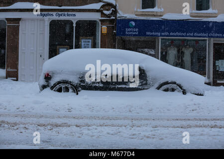 Peebles, Schottland. 1 Mär, 2018. UK Wetter: Autos in Drifts auf der High Street in Peebles Kredit klemmt: Edward Shoote/Alamy leben Nachrichten Stockfoto