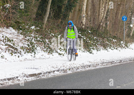 Ashford, Kent, Großbritannien. März 2018. Wetter in Großbritannien: Bestie aus dem Osten. Eine leichte Schneedusche heute Morgen im Stadtzentrum von Ashford in Kent mit lokalen Mitarbeitern, die die potenziell gefährlichen Gehwege und Gehwege durchgraten. Das Wetter wird sich voraussichtlich heute und bis Freitag verschlechtern. Die aktuelle Temperatur liegt bei -4 Grad, fühlt sich aber wie -11 Grad an Ein Mann, der im Schnee radeln kann. Fotowredit: Paul Lawrenson/Alamy Live News Stockfoto