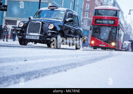 London, Vereinigtes Königreich, 1. März 2018 Den berühmten schwarzen Taxis und Busse fahren auf schneebedeckten Straßen von Central London während einer Schnee Squall. Winde aus Sibirien haben bei extrem kalten Temperaturen und Schnee Sturmböen in ganz Europa, einschließlich des Vereinigten Königreichs führte. Mehrere U- und S-Bahn Einrichtungen betroffen, und die Menschen sind gezwungen, alternative Verkehrsmittel zu benutzen. Schnee Sturmböen wird erwartet, dass sie für ein paar Tage in dieser Woche fortsetzen. Rafique Hasaan/Alamy leben Nachrichten Stockfoto