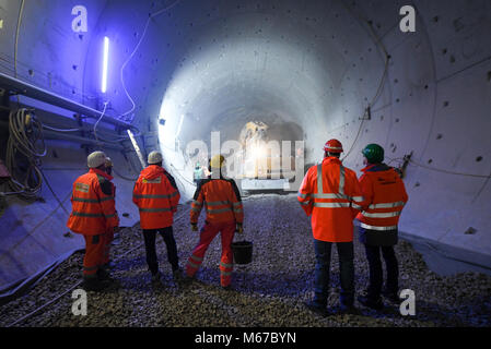 Rastatt, Deutschland. 01 Mär, 2018. Ein Bagger pflügen seinen Weg durch Beton und Stahl in Rastatt, Deutschland, 01. März 2018. Bauarbeiter beobachten das Geschehen aus der Ferne. Schäden an der neuen Entwicklung der Strecke Karlsruhe-Basel im Jahr 2017 sah, Wasser und Erde die Website infiltrieren. Mit den Tracks zu versinken, ein Bereich des Tunnels hatte mit 2000 Kubikmeter Zement mit einem bohren Maschine abgedichtet werden. Diese konkrete Anschläge werden jetzt entfernt. Quelle: Patrick Seeger/dpa/Alamy leben Nachrichten Stockfoto