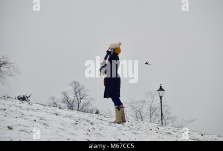 London, Großbritannien. 28 Feb, 2018. UK Wetter: eine Frau gegen die Kälte im Schnee umhüllt im Alexandra Palace im Norden von London UK 1. März 2018: Simon Leigh/Alamy leben Nachrichten Stockfoto