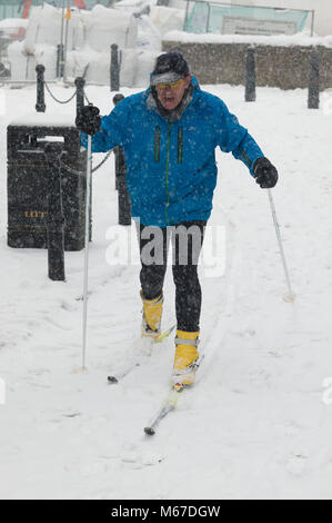 Exeter, Devon, Großbritannien. 1. März 2018. Das Tier aus dem Osten trifft Sturm Emma in Exeter als rote Wetter Warnung ausgegeben wird. Ein Mann nimmt, um Skier herum zu erhalten. Credit: Theo Moye/Alamy leben Nachrichten Stockfoto