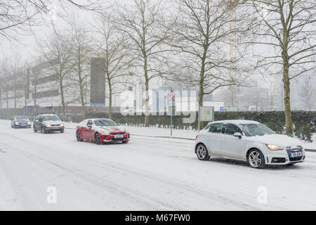 Southampton, Großbritannien. 1st März 2018. Bei starkem Schnee wurde die Universität von Southampton (England, Großbritannien) wegen widriger und gefährlicher Wetterbedingungen für den Rest des Tages und morgen geschlossen. Hier sind Autos zu sehen, die bei starkem Schneefall langsam entlang der University Road auf dem Highfield Campus fahren. Stockfoto