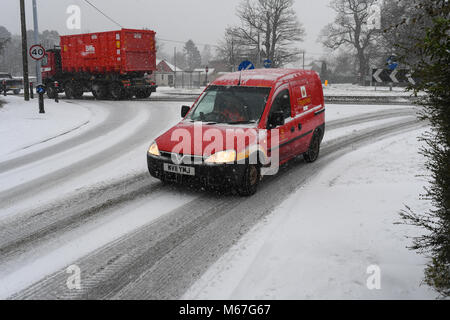 Southampton, Großbritannien. 1. März, 2018. Donnerstag, 1. März 2018 UKsnow West Wellow Southampton, England. Die lokale Briefträger seinen Weg durch den Schnee kämpfen und liefert seinen Post an die Dorfgemeinschaft von West Gelb in der Nähe von Romsey, so wie der Schnee wirklich beginnt in durch Sturm Emma geschoben zu kommen, Sturm Emma kombiniert mit dem "Tier aus dem Osten' hits West Wellow, Romsey Hampshire am späten Nachmittag verursacht Chaos auf der A36 die Hauptroute von Southampton nach Salisbury. Autos und Lastwagen auf die vielen Hügel blockiert Verkehr stecken geblieben. Credit: PBWPIX/Alamy leben Nachrichten Stockfoto