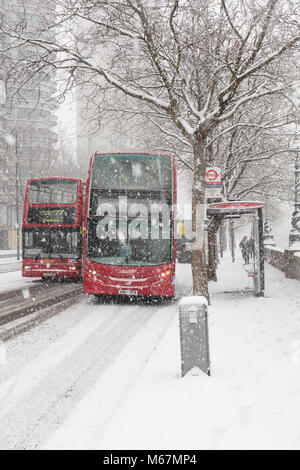 Zwei Londoner Busse auf der Straße während der Schneesturm Stockfoto