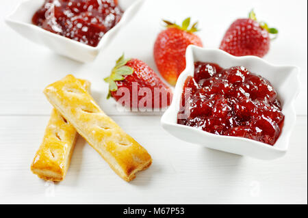 Erdbeere Obst und Marmelade und Blätterteig Stick in eine herzförmige Platte Stockfoto