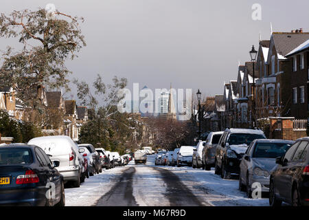Schnee, Winter Blick hinunter auf der Suche Tyrwhitt Straße, Brockley, London SE4. St John's Church und Canary Wharf sind im Hintergrund Stockfoto