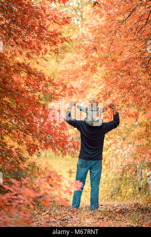 Vater Sohn piggyback Ride im Herbst Park Stockfoto