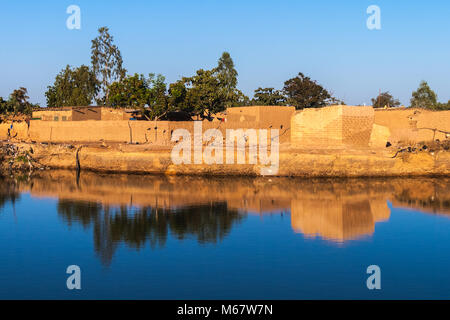 Eastern Township von Ouagadougou an einem sonnigen Tag mit einer Bohrung mit Regenwasser im Vordergrund gefüllt, Burkina Faso. Stockfoto